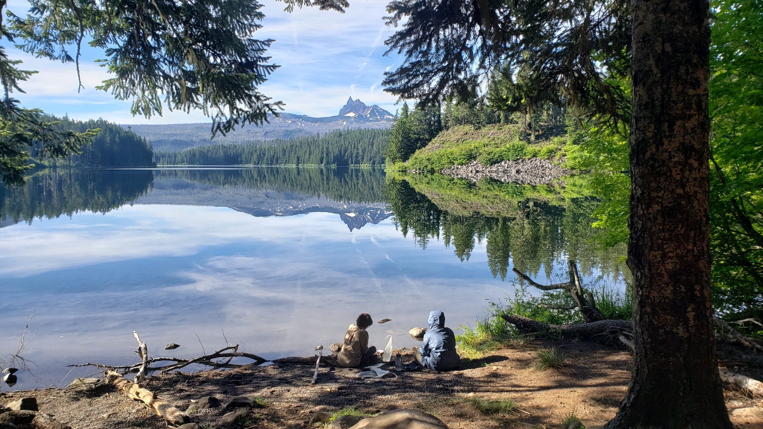people sitting next to lake